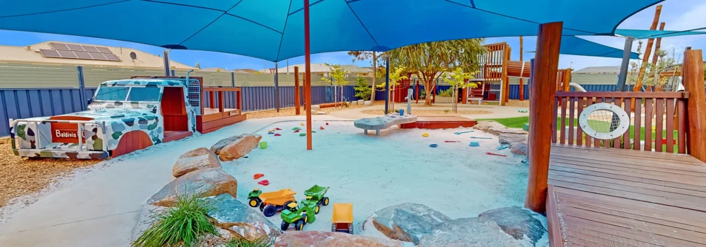 Shaded outdoor playground with sandpit at Baldivis Day Care..