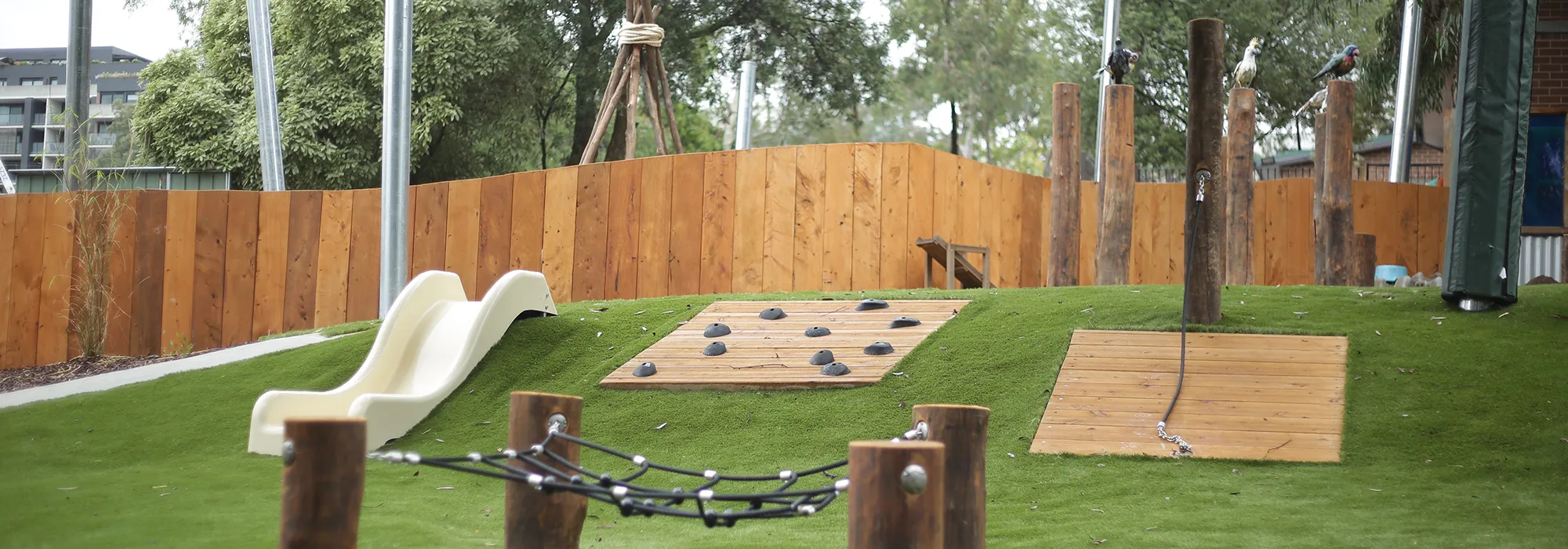 Outdoor playground at Doncaster East childcare, featuring a slide and climbing wall.