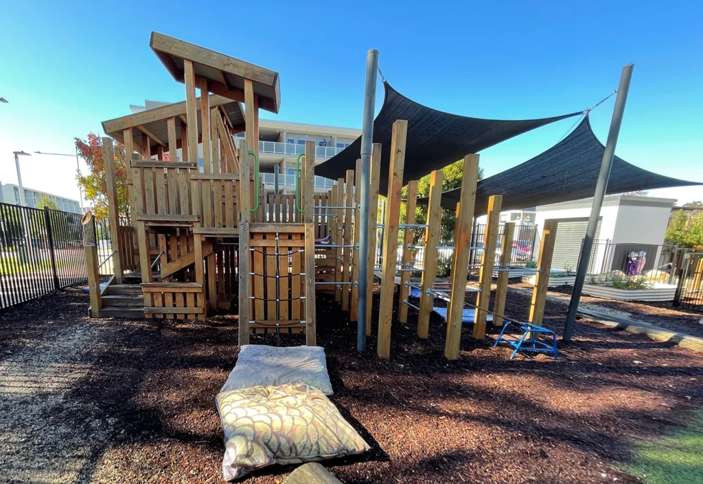 Playground equipment at Amaroo childcare with a large timber fort.