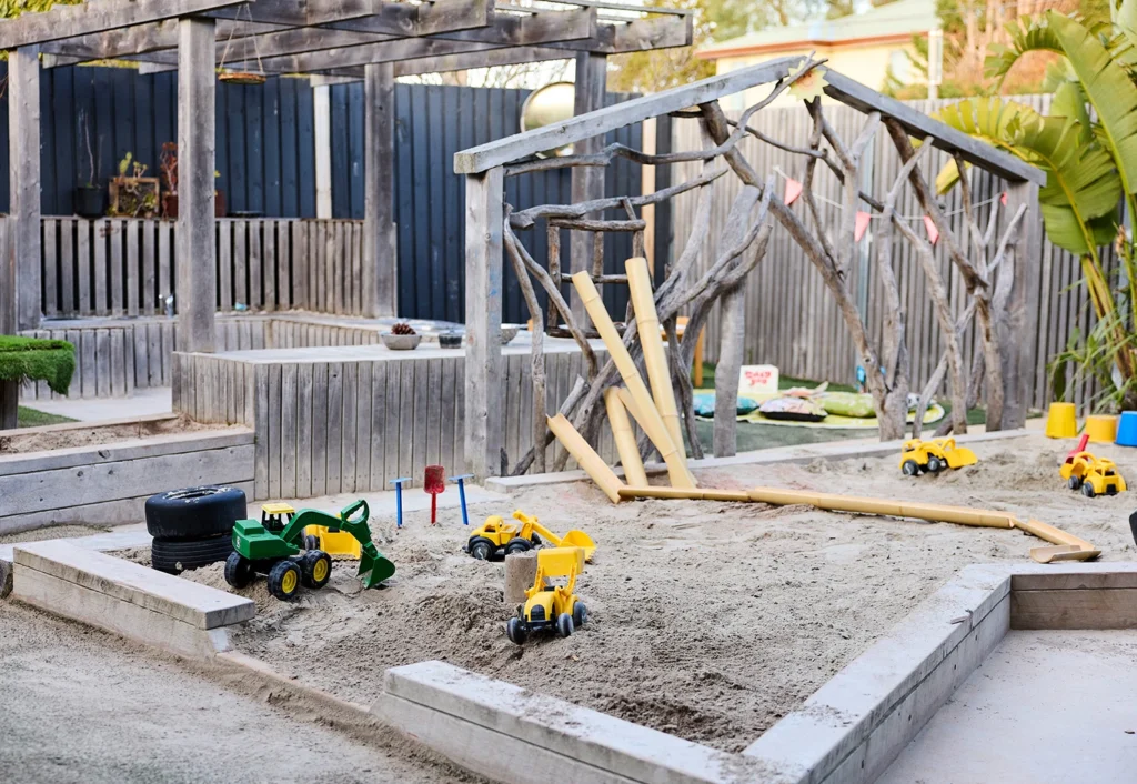 Sandpit at Geelong childcare with a mud kitchen in the background.