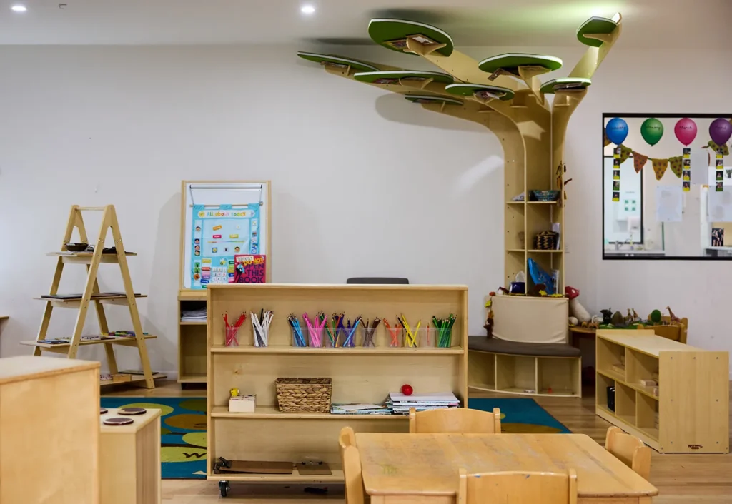 A kindergarten room with a timber reading tree with seat at Geelong Daycare