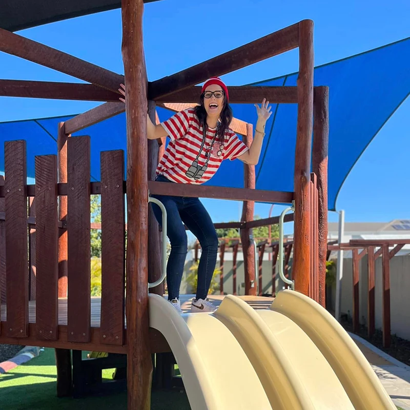 Educator dressed as book character "Where's Wally" and hiding on playground equipment